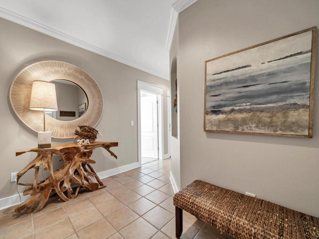 a living room with a table and a mirror at Penthouse Paradise Condo at Seacrest in Rosemary Beach
