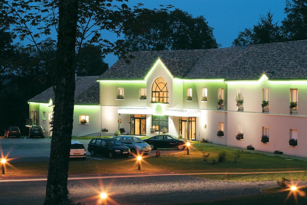 a building with cars parked in front of it at night at Hôtel-restaurant Le Tulipier in Vienne-le-Château
