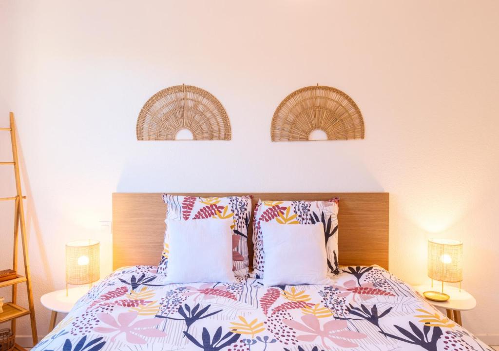 - une chambre avec un lit et des oreillers colorés dans l'établissement Maison des Embruns, à Biscarrosse