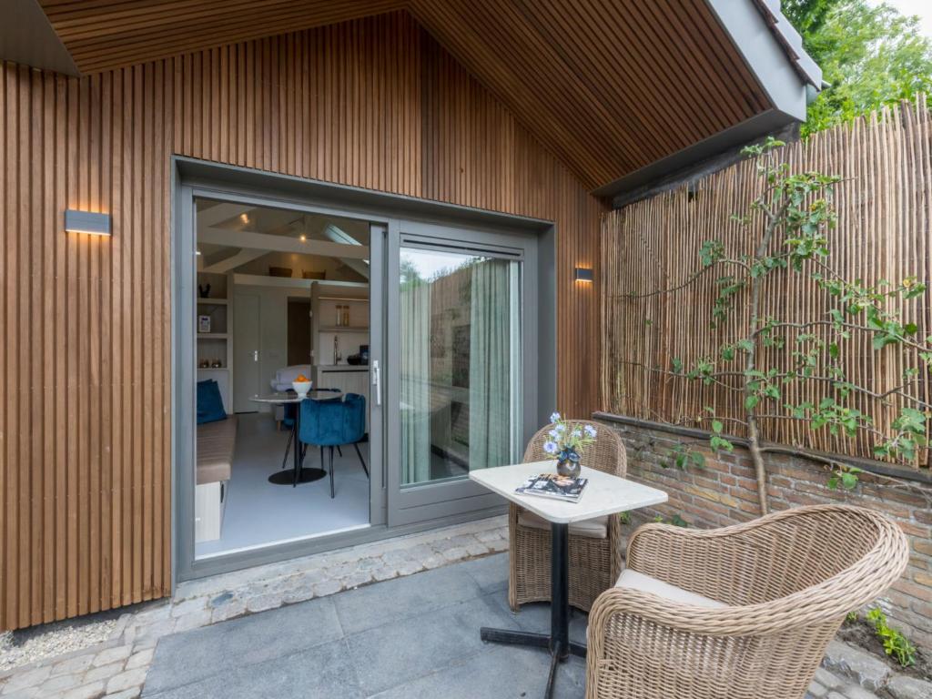 a patio with a table and chairs on a building at Chalet Residence Domburgse Duinen by Interhome in Domburg