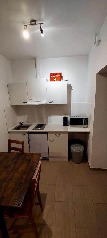 a kitchen with white cabinets and a wooden table at Monteurwohnungen in Wanzleben in Wanzleben