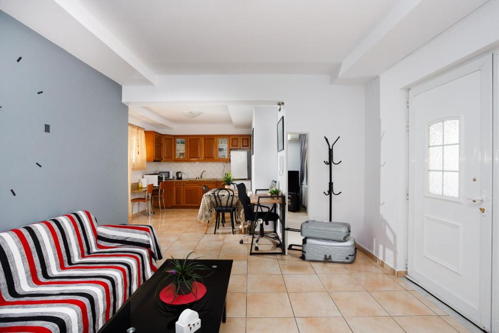 a living room with two couches and a kitchen at Sunrise Apartment in Heraklio