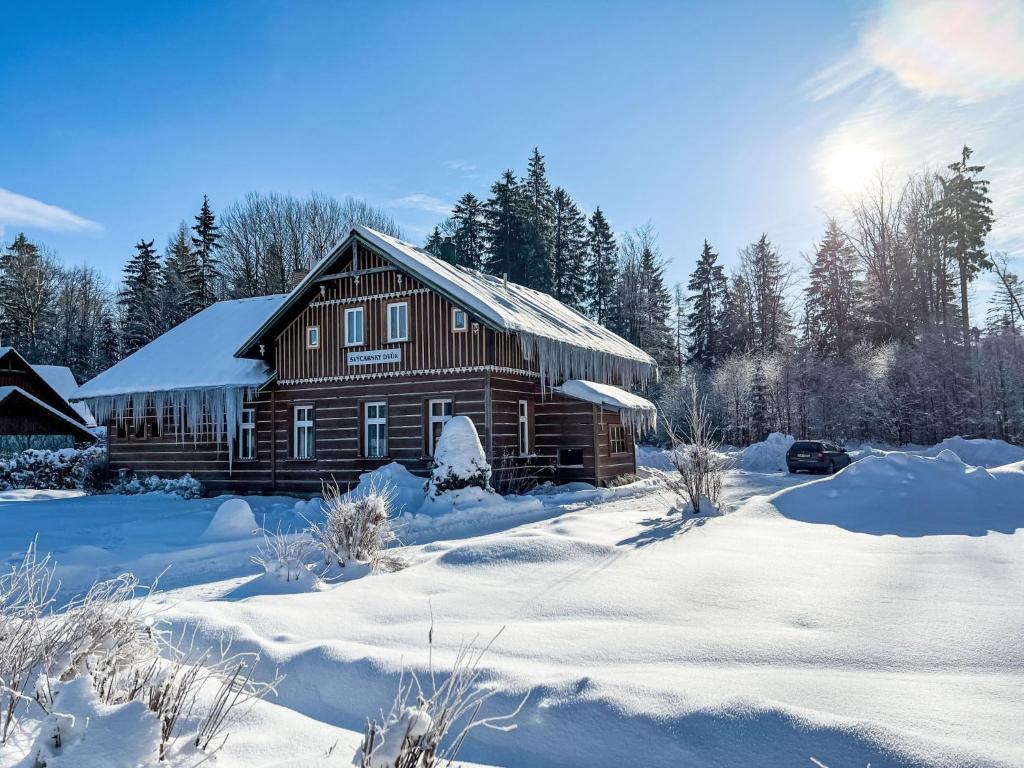 eine Holzhütte im Schnee mit schneebedeckten Bäumen in der Unterkunft Holiday Home Švýcarský dvůr by Interhome in Janské Lázně