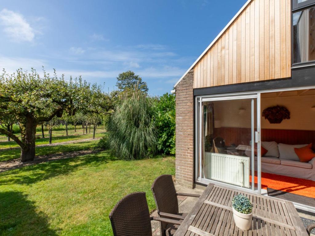 a patio with a table and chairs in a yard at Holiday Home Buitenplaats Schouwen nr 86 by Interhome in Burgh Haamstede
