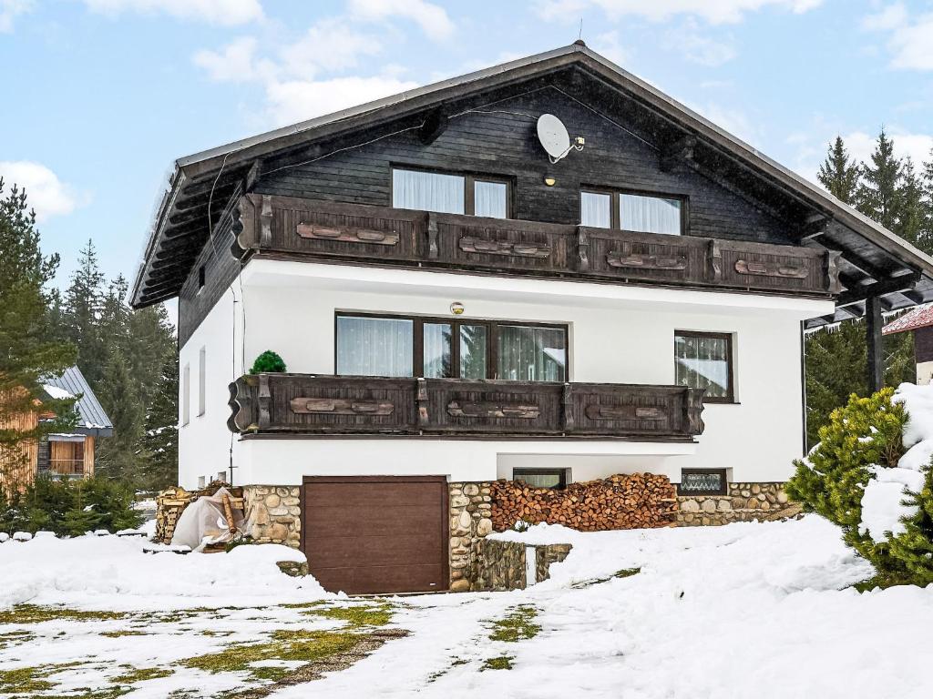 a house in the snow with a garage at Holiday Home Burger by Interhome in Harrachov