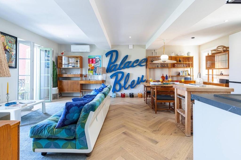 un salon avec un canapé bleu et une cuisine dans l'établissement 2 chambres, balcons, vue imprenable, climatisation - PALACE BLEU, à Nice