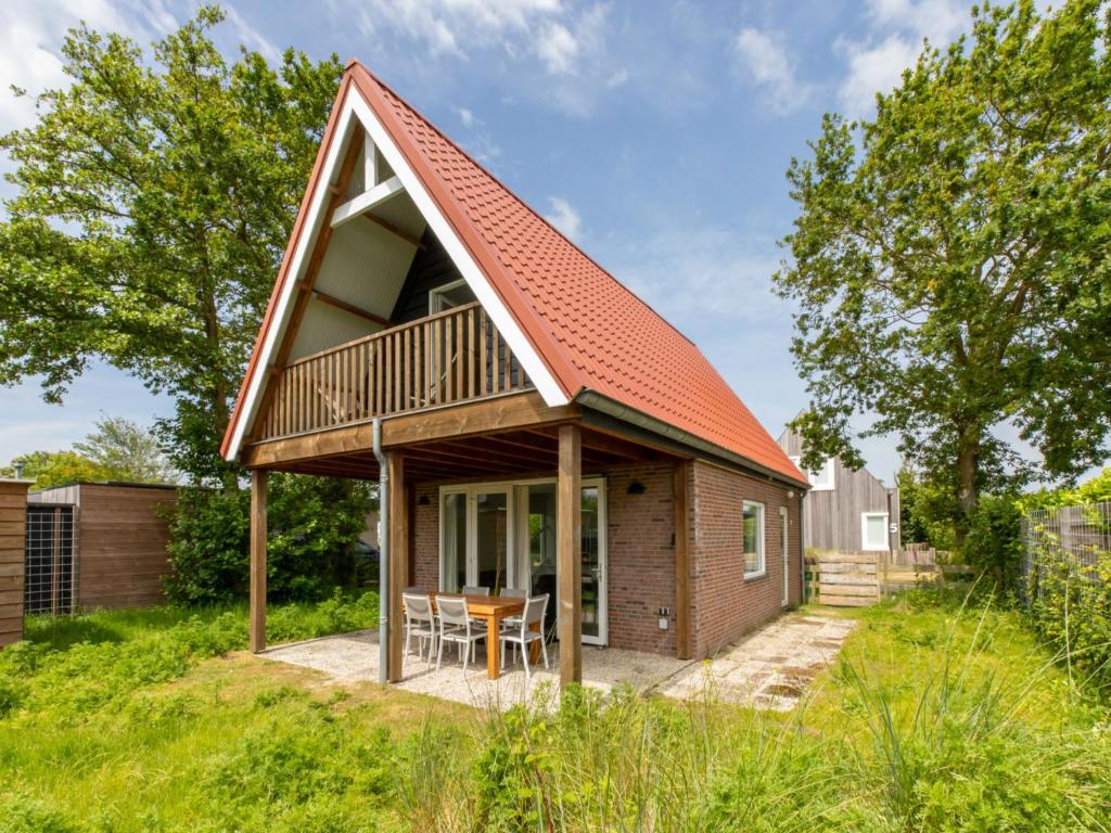 a small house with an orange roof at Holiday Home Horizon- Sea & Sun by Interhome in Renesse