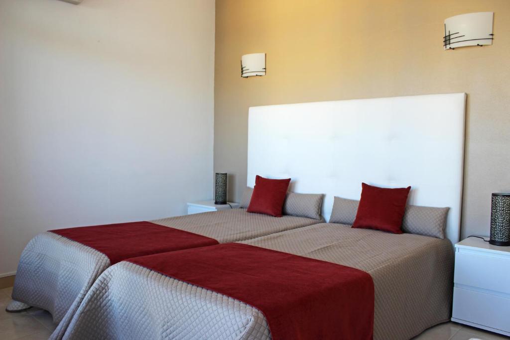 ポルティマンにあるPraia da Rocha Tarikのベッドルーム1室(赤い枕のベッド2台付)