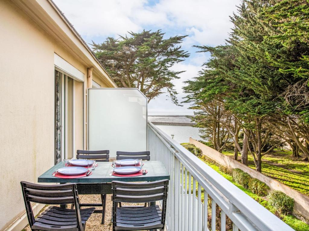 y balcón con mesa, sillas y nevera. en Apartment Les Tilleuls-1 by Interhome, en La Bernerie-en-Retz