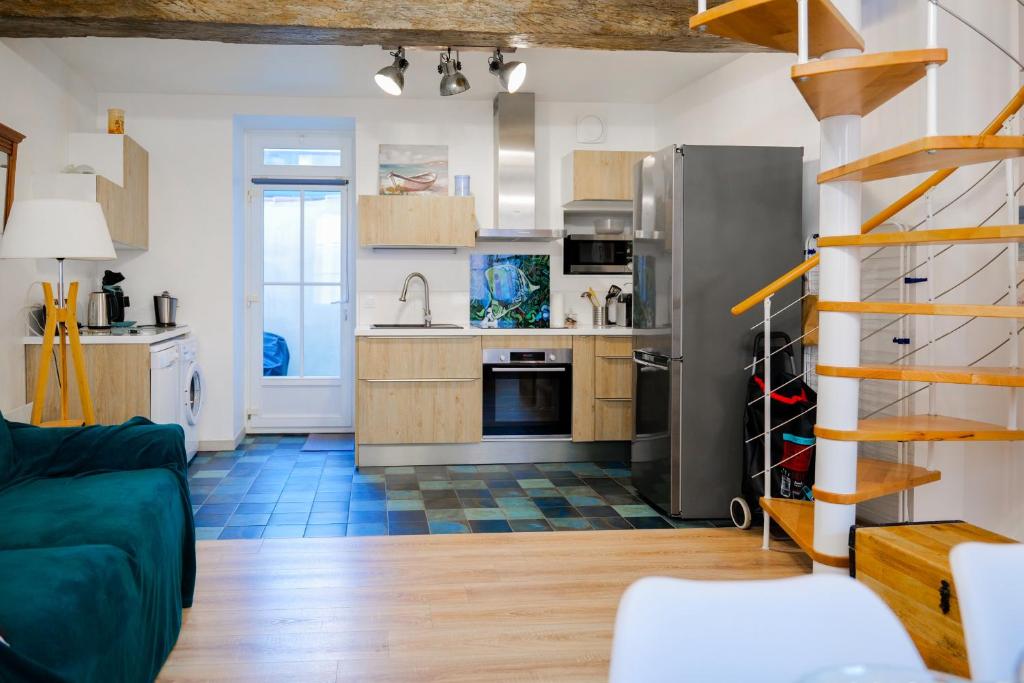 un salon avec une cuisine et un escalier dans l'établissement Appartement situé au cœur des belles ruelles sablaises - 5 pers, à Les Sables-dʼOlonne