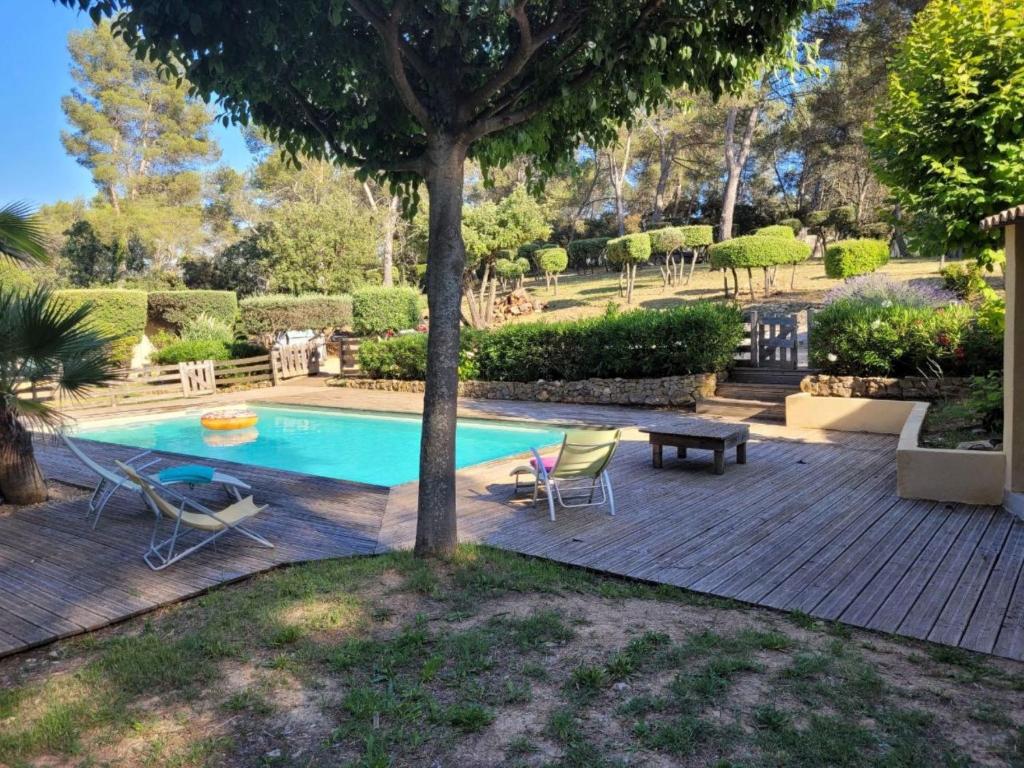 une piscine avec des chaises, une table et un arbre dans l'établissement Holiday Home Villa au coeur de la Foret by Interhome, à Puget-Ville