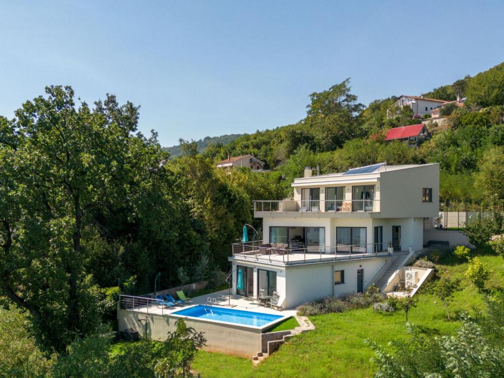 a white house with a swimming pool in a yard at Villa Anna by Interhome in Opatija