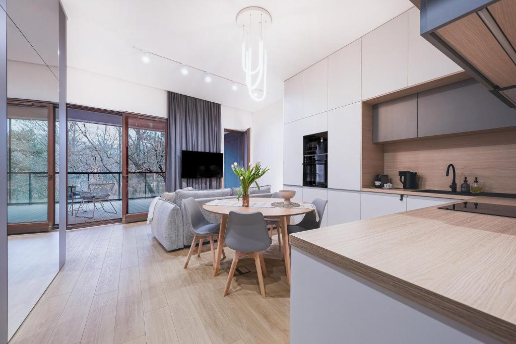 ウッチにあるPark Zen, taras i widok na parkのテーブルと椅子のあるキッチンとリビングルーム