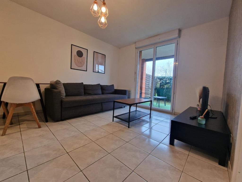 un salon avec un canapé et une table dans l'établissement Beau soleil - Résidence avec Parking et piscine - Proche airport, à Blagnac