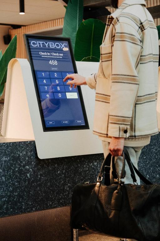 a woman holding a handbag next to a tablet at Citybox Oslo in Oslo