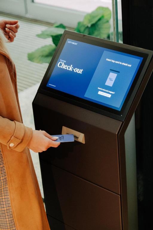 a woman is using a check out machine at Citybox Oslo in Oslo