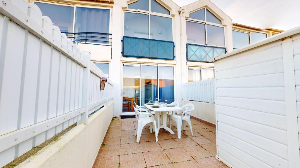 un balcon avec une table et des chaises dans un immeuble dans l'établissement La Pause Oceane, à Bretignolles-sur-Mer