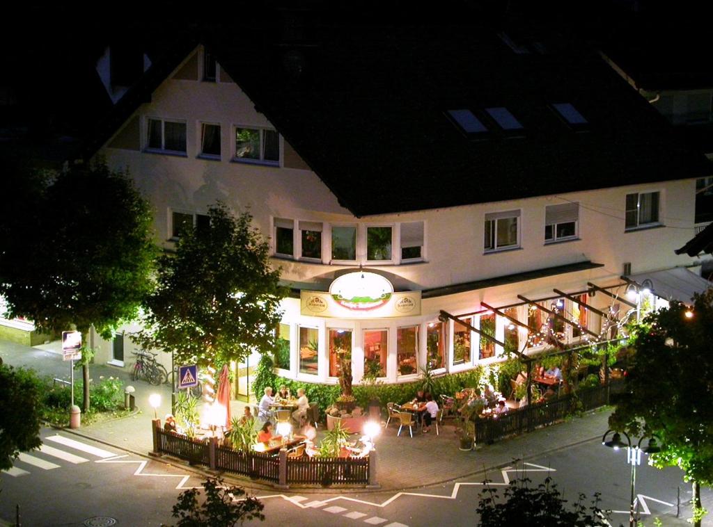 eine Gruppe von Menschen, die nachts vor einem Gebäude sitzen in der Unterkunft Hotel Es Lämmche in Breuberg