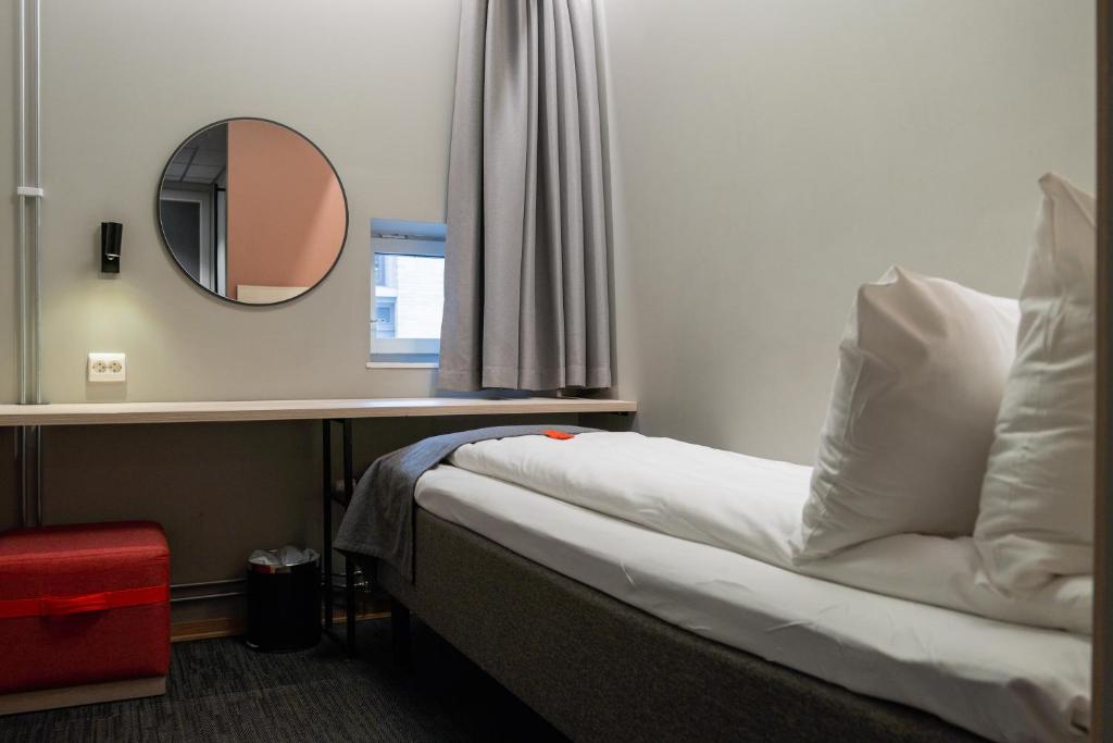 a hotel room with a bed and a mirror at Citybox Oslo in Oslo
