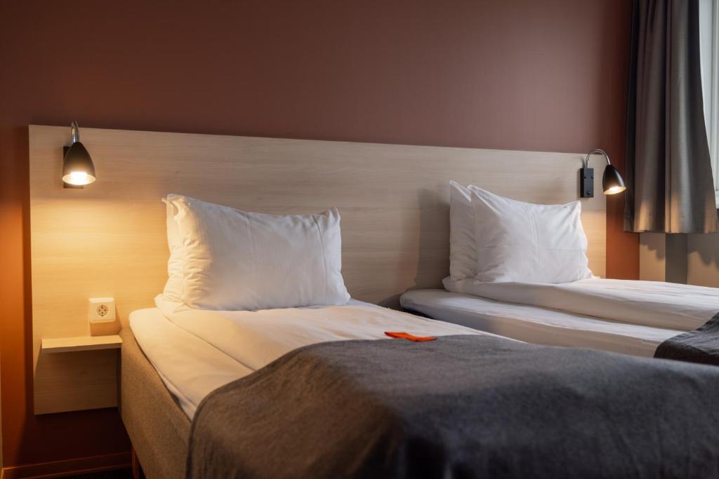 a hotel room with two beds with white pillows at Citybox Oslo in Oslo