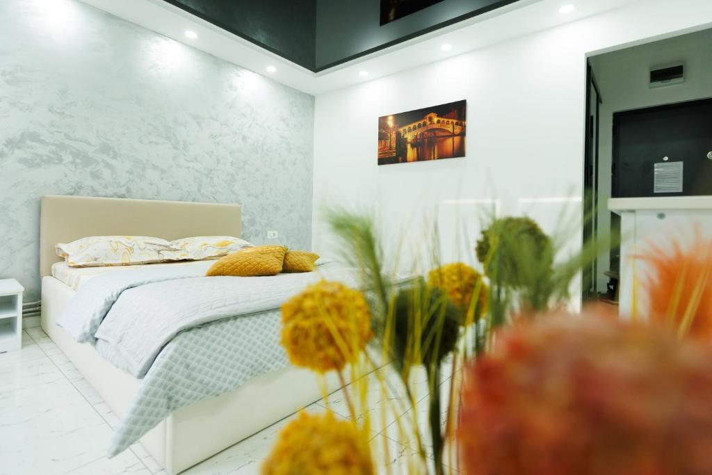 a bedroom with a bed and flowers in a room at Archi's Apartament in Galaţi