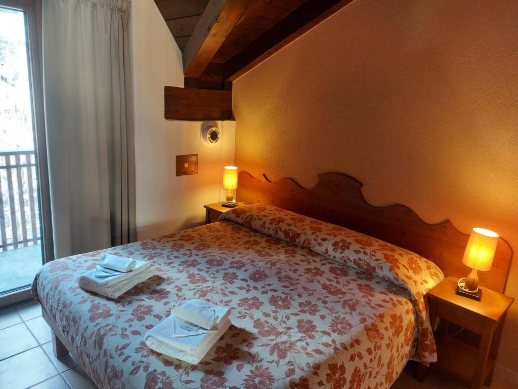 sypialnia z łóżkiem i dwoma ręcznikami na nim w obiekcie Residence Les Lacs w mieście Bardonecchia