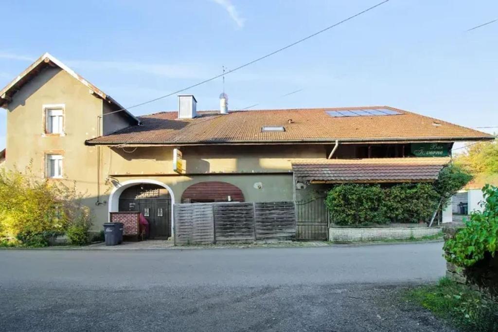 a house with a garage in front of it at Maison accueillante avec jardin proche d'Échenans. in Échenans