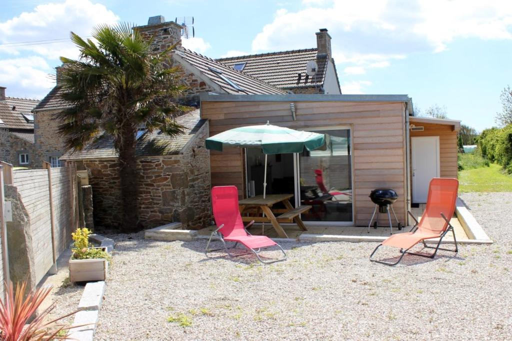 a patio with a table and two chairs and an umbrella at Gite du Becquet in Le Rozel