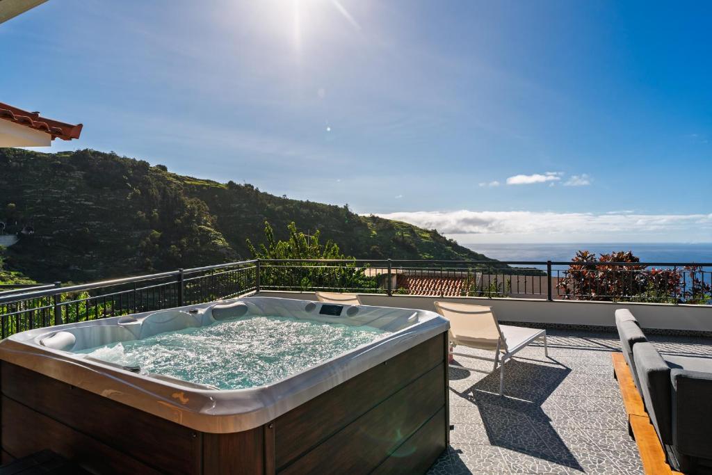 a hot tub on the balcony of a house at Casa de Pedra by An Island Apart in Ribeira Brava