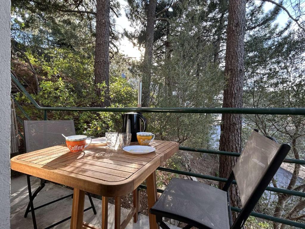 - une table en bois sur un balcon avec une cafetière dans l'établissement Appart Studio 4 couchages BANYULS SUR MER BN590-001, à Banyuls-sur-Mer