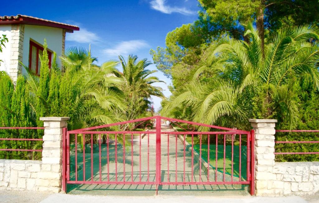 カスペにあるApartamentos Caspeのヤシの木の家の前の赤門