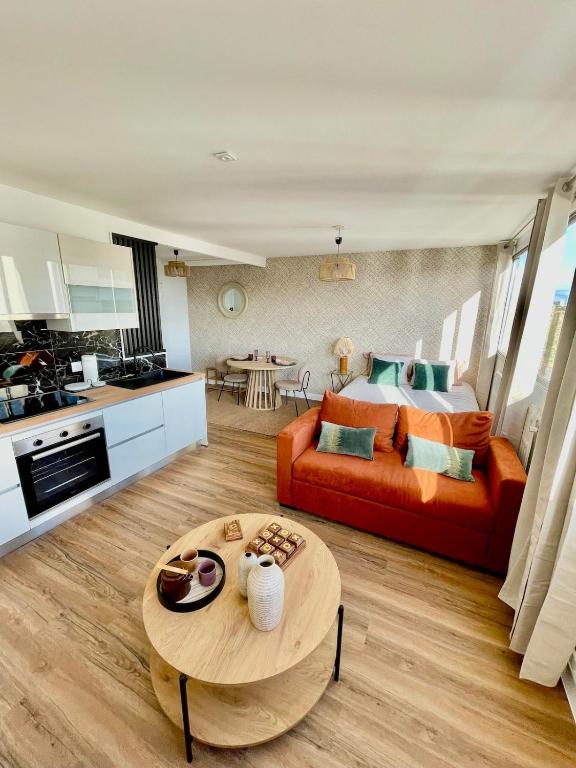 un salon avec un canapé et une table dans l'établissement Cozy apartment with parking and panoramic views!, à Amiens