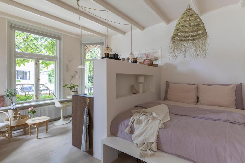 une chambre avec un lit violet dans une pièce avec des fenêtres dans l'établissement Magnolia Tree, à Bergen