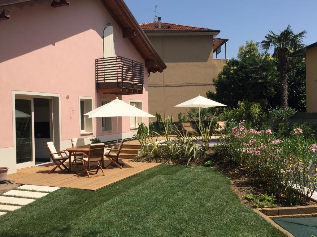 un cortile con tavolo, sedie e ombrelloni di Villa Arzilla a Desenzano del Garda