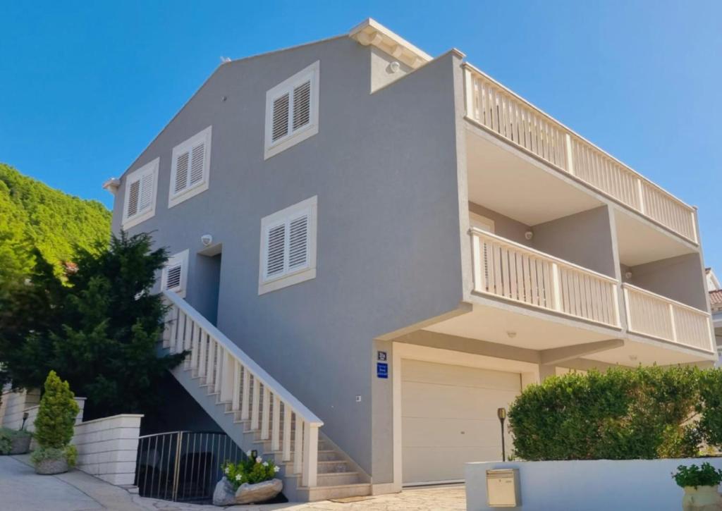 a white house with stairs and a garage at VILLA DORA ZULJANA PELJESAC CROATIA in Žuljana