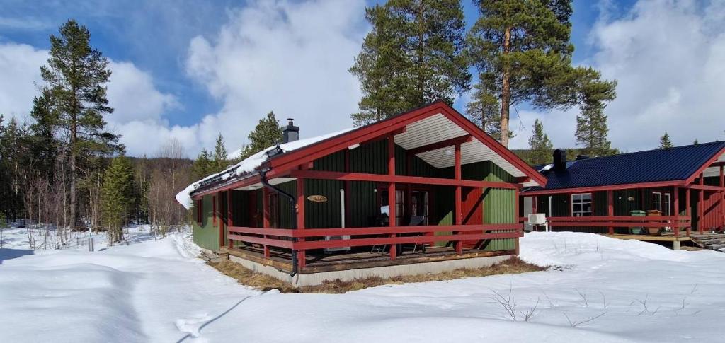 a red and green building in the snow at Sauna | Wi-Fi | Terrace | Wood stove | Cable TV in Lofsdalen