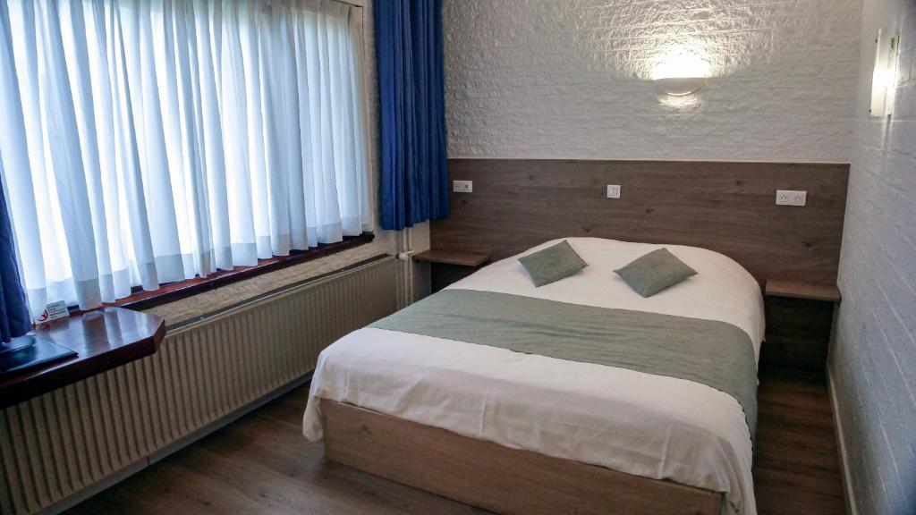 Postel nebo postele na pokoji v ubytování Hotel Dordrecht