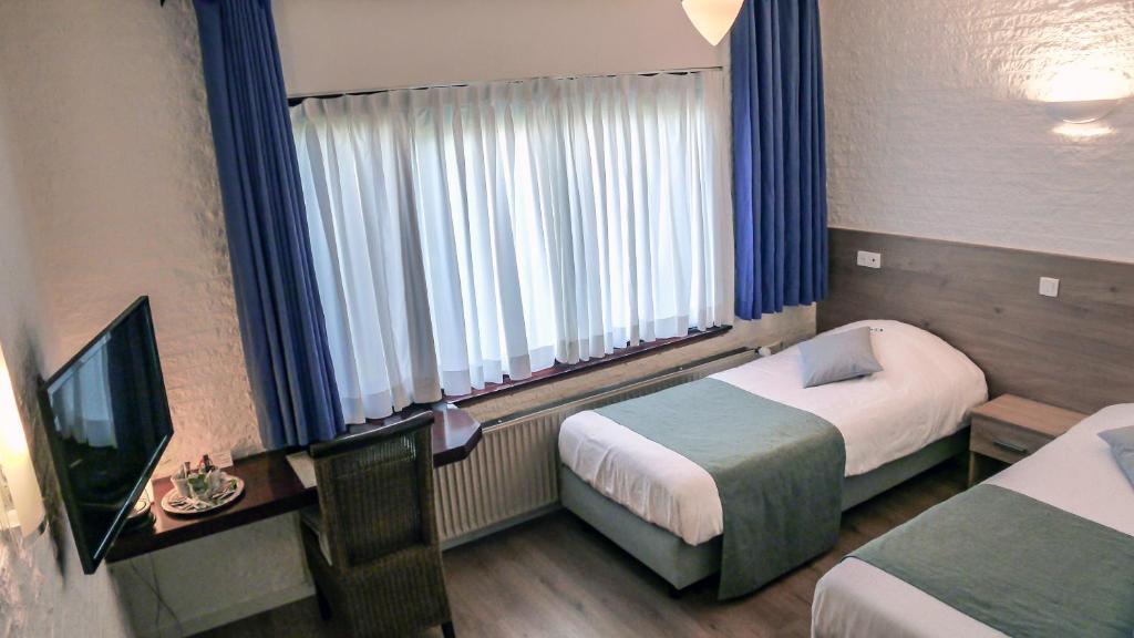 Postel nebo postele na pokoji v ubytování Hotel Dordrecht