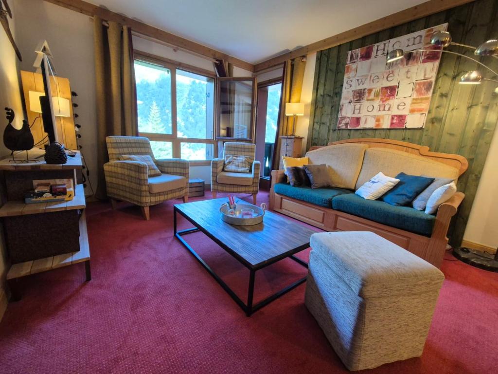 un salon avec un canapé et une table dans l'établissement Arc 1950 - Appartement 2 chambres - 6 personnes - 53m2-ski aux pieds - Les Sources de Marie, à Arc 1950