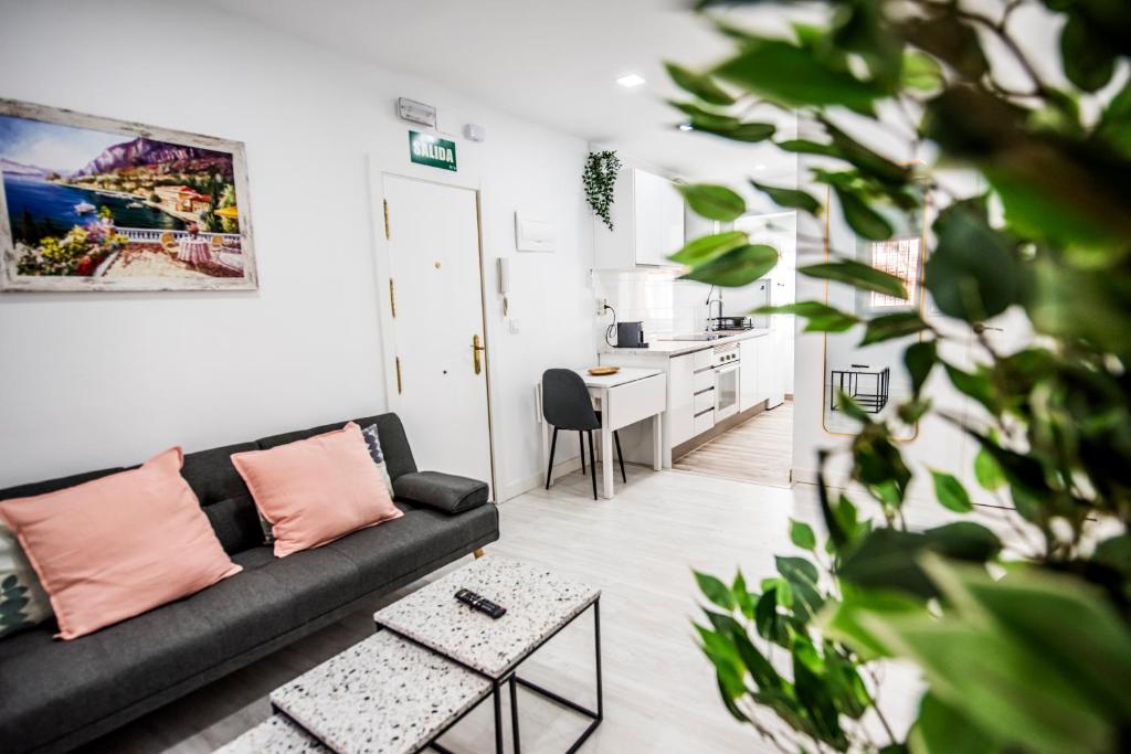 un salon avec un canapé et une table dans l'établissement Encantador apartamento en Barajas by beBalmy, à Madrid
