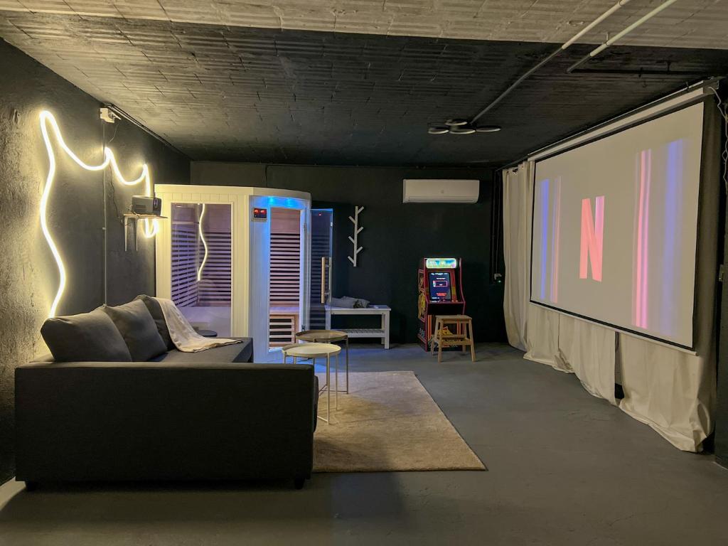 - un salon avec un canapé et un écran de projection dans l'établissement La Terrasso Sauna à Toulon - Parking privé - 6 couchages, à Toulon