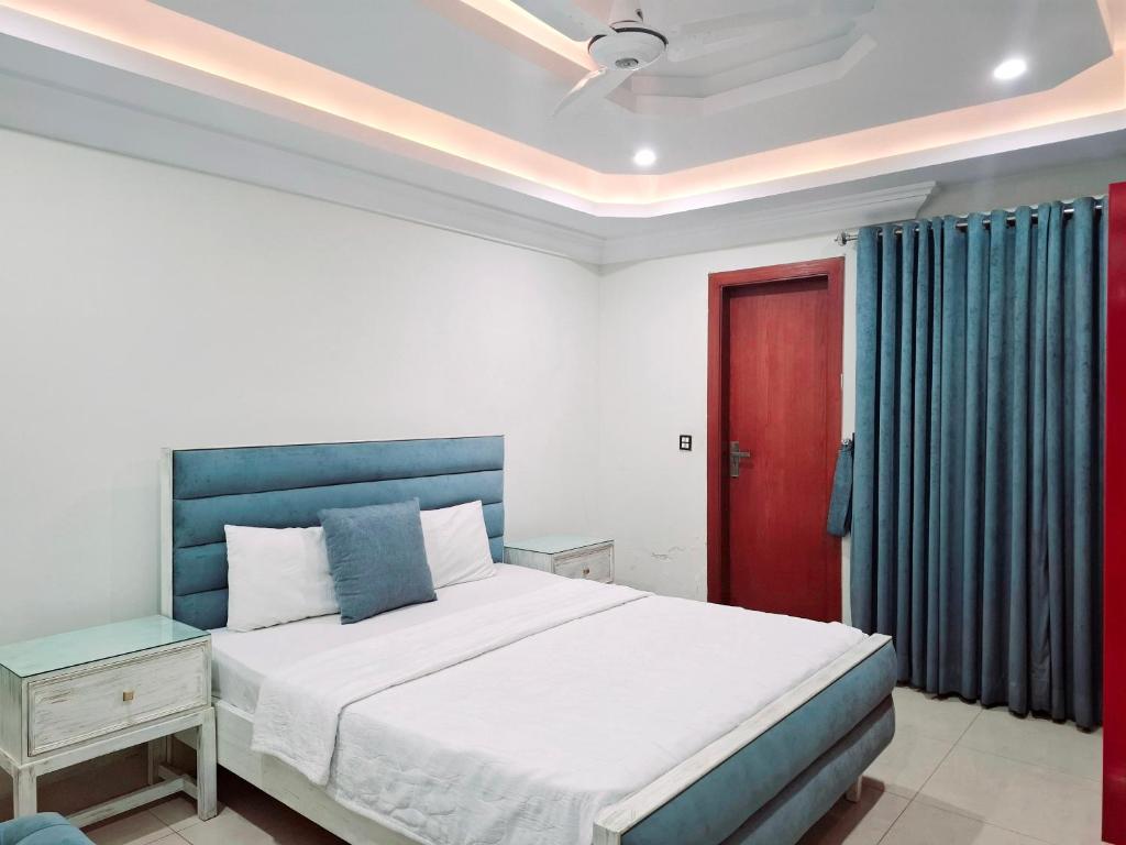 a bedroom with a bed and a red door at Royal Galaxy Hotel & Residence - Near Islamabad International Airport & Motorway in Islamabad