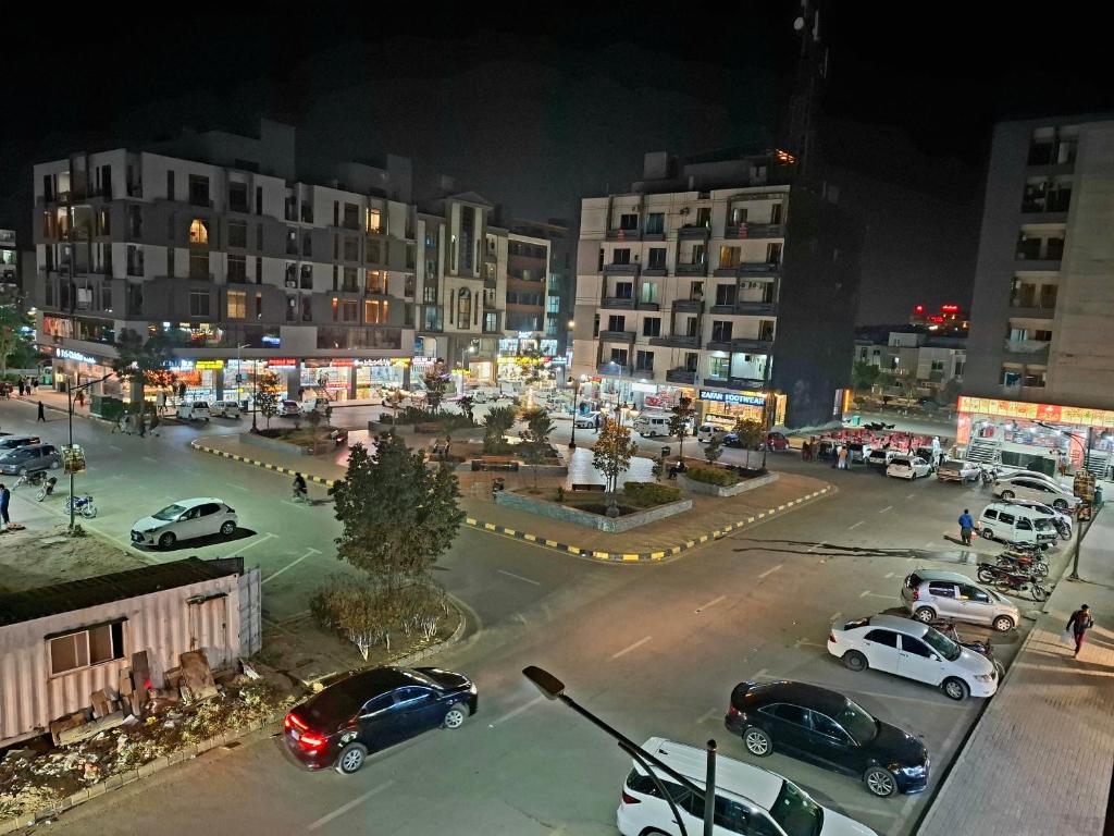 a city with cars parked in a parking lot at night at Royal Galaxy Hotel & Residence - Near Islamabad International Airport & Motorway in Islamabad