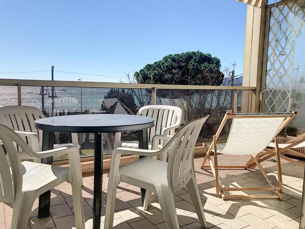 une table et des chaises sur une terrasse avec vue sur l'océan dans l'établissement Bord de mer, terrasse vue mer 228L, à Cannes
