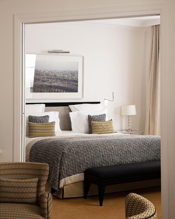 a bedroom with a large bed and a chair at Le Burgundy Paris in Paris