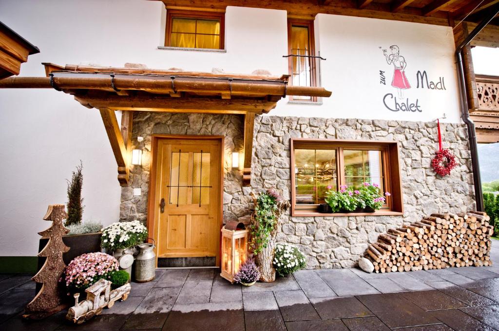 a building with a stone facade with a wooden door at Superior Chalet Tiroler Madl in Achenkirch