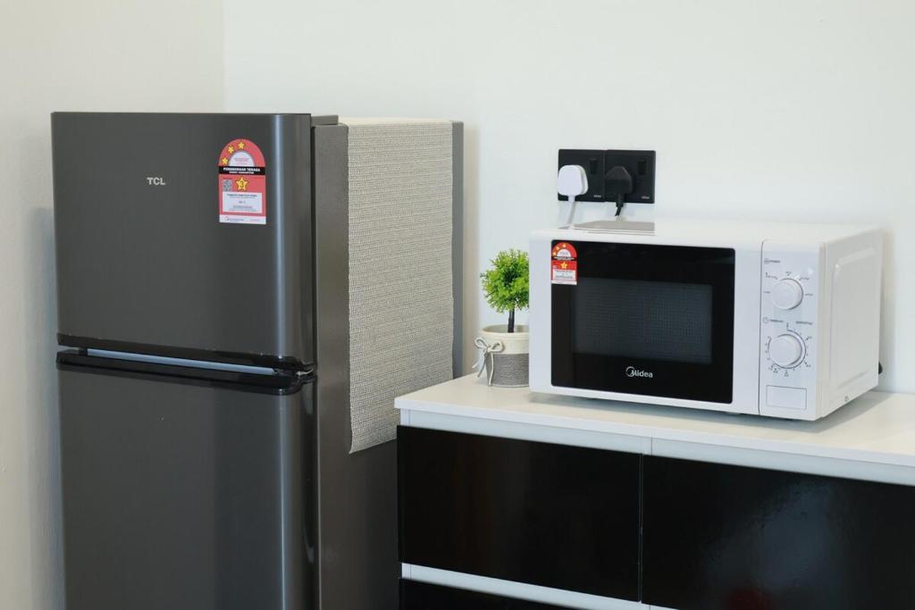 Il comprend une cuisine équipée d'un réfrigérateur et d'un four micro-ondes. dans l'établissement 嘿夏天 HeySummer-13pax l 200mJetty l Netflix l Games l Youtube, à Mersing