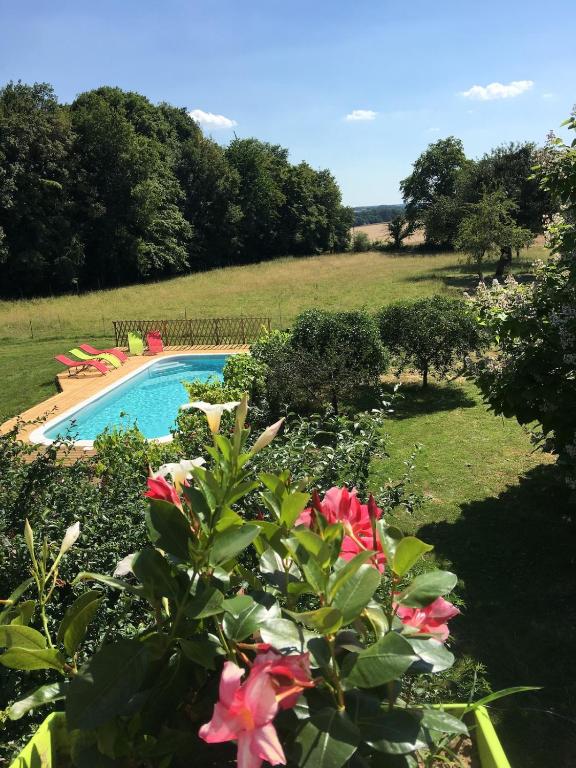 - une vue sur la piscine ornée de fleurs roses dans l'établissement Le Plessis, Stone Farmhouse Loft with Gardens and Pool, à Neuillé-le-Lierre