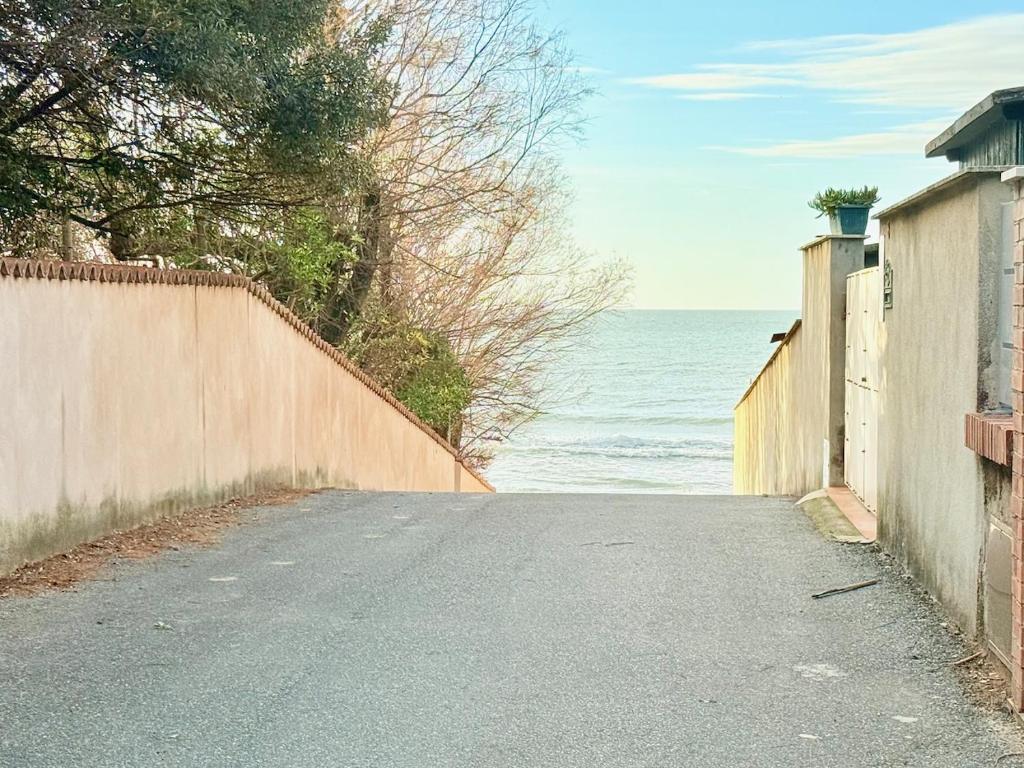 eine leere Straße neben dem Meer mit einem Zaun in der Unterkunft Appartamento La Cavaliera in San Vincenzo