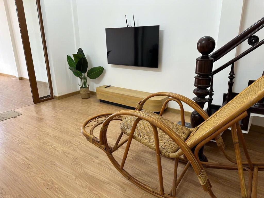 ein Wohnzimmer mit einem Stuhl und einem TV an der Wand in der Unterkunft Mary House in Buôn Ea Trum